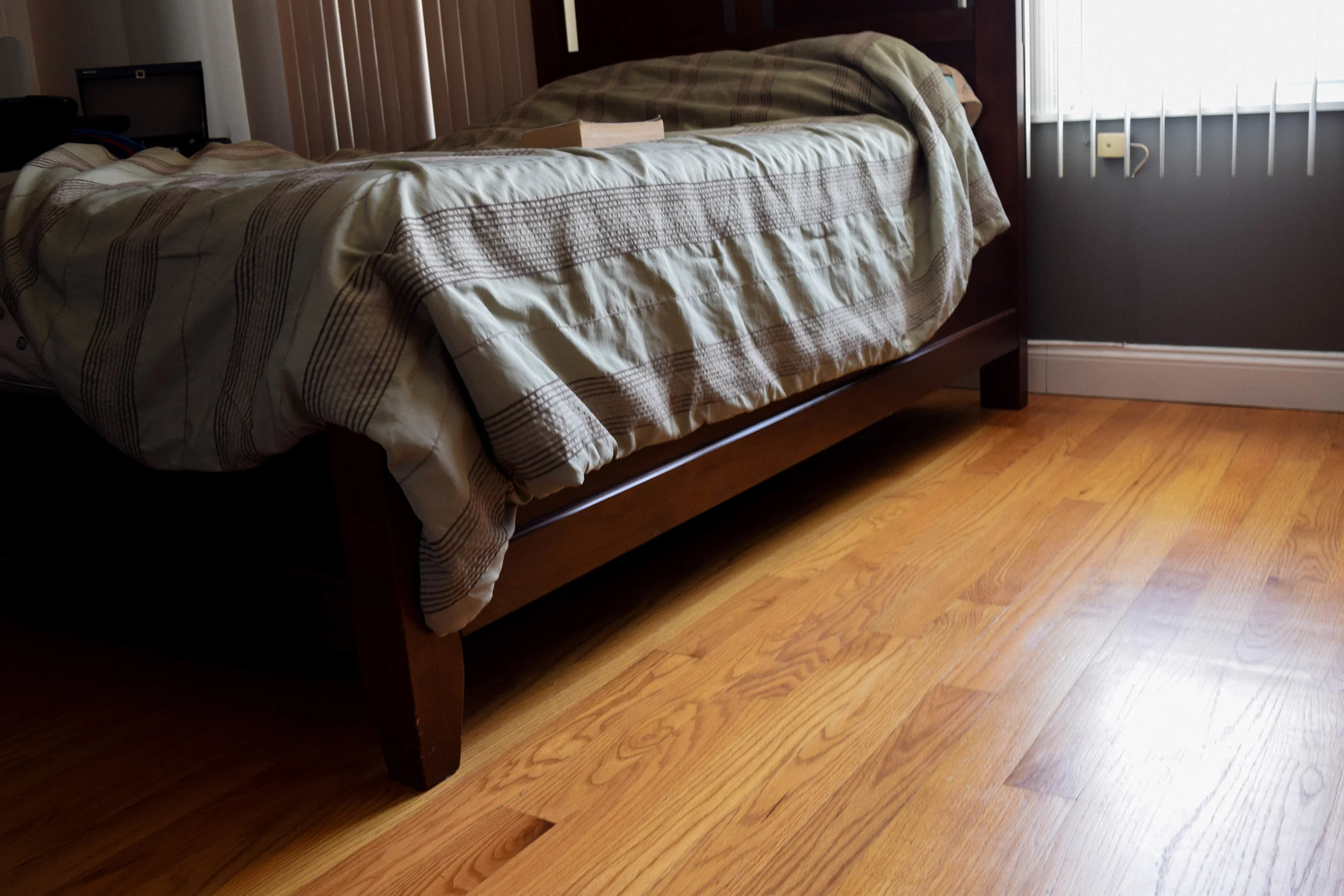 Glossy red oak hardwood flooring installed in a bedroom